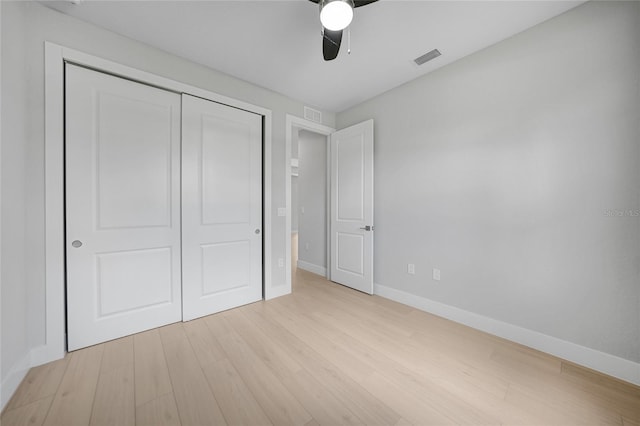 unfurnished bedroom with light hardwood / wood-style floors, ceiling fan, and a closet