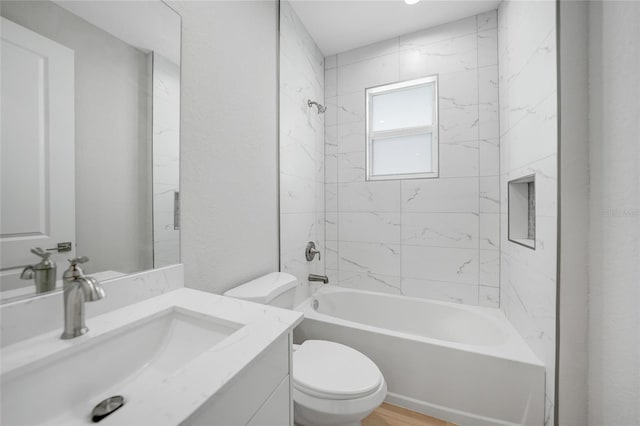 full bathroom featuring toilet, vanity, and tiled shower / bath