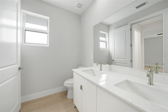 bathroom with hardwood / wood-style floors, vanity, and toilet