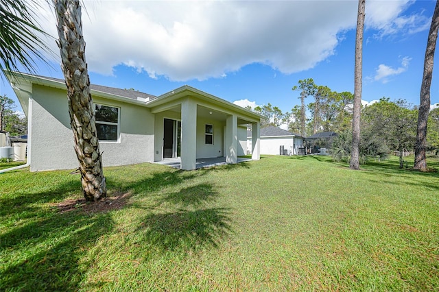 rear view of house featuring a yard and a patio area