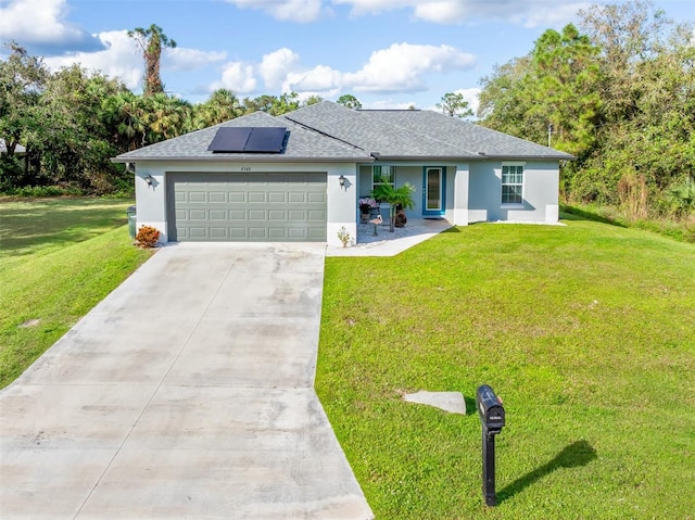 ranch-style house with solar panels, a front yard, and a garage