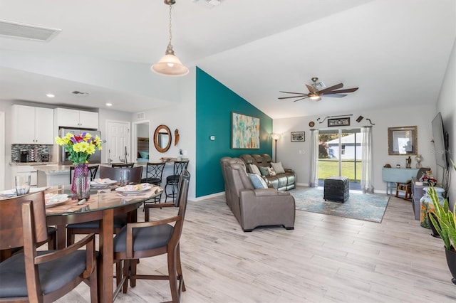 dining space featuring lofted ceiling, ceiling fan, and light hardwood / wood-style flooring