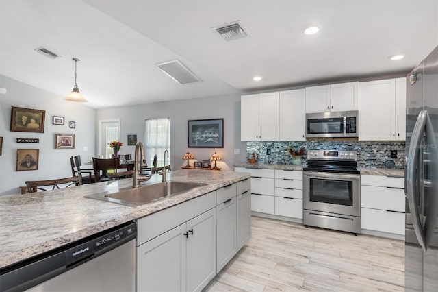 kitchen with white cabinetry, stainless steel appliances, and sink