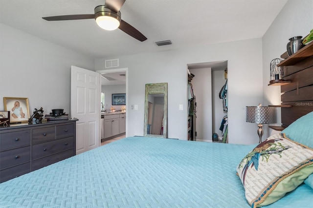 bedroom featuring ceiling fan, a walk in closet, and a closet