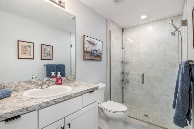 bathroom featuring vanity, toilet, and an enclosed shower