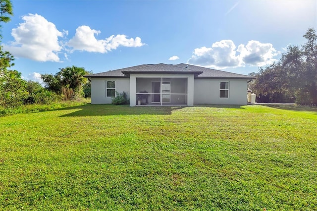 back of property with a sunroom and a lawn