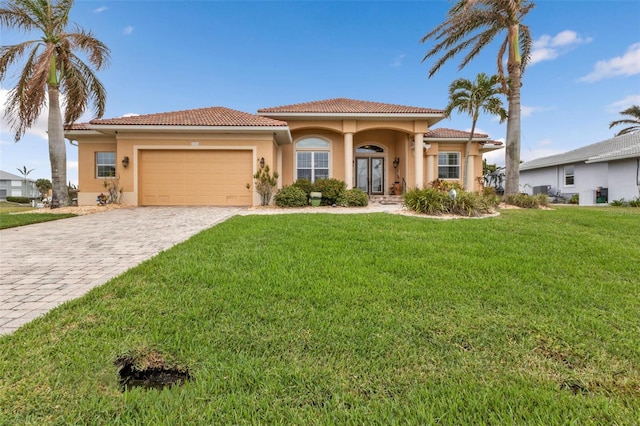 mediterranean / spanish-style house with a garage and a front lawn