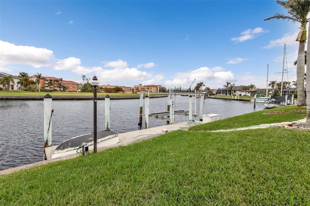 view of dock with a water view and a yard