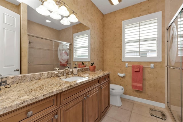 bathroom featuring tile patterned floors, toilet, an inviting chandelier, vanity, and a shower with door