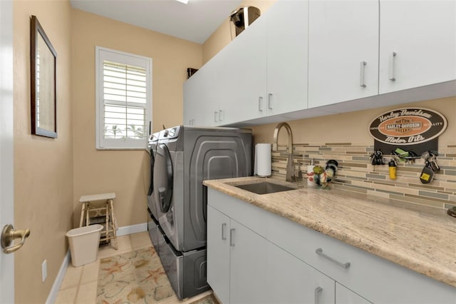 laundry room with cabinets, separate washer and dryer, sink, and light tile patterned floors