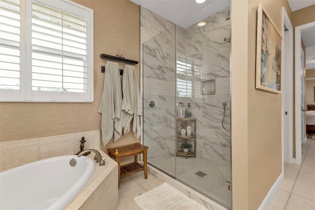 bathroom with tile patterned floors and shower with separate bathtub