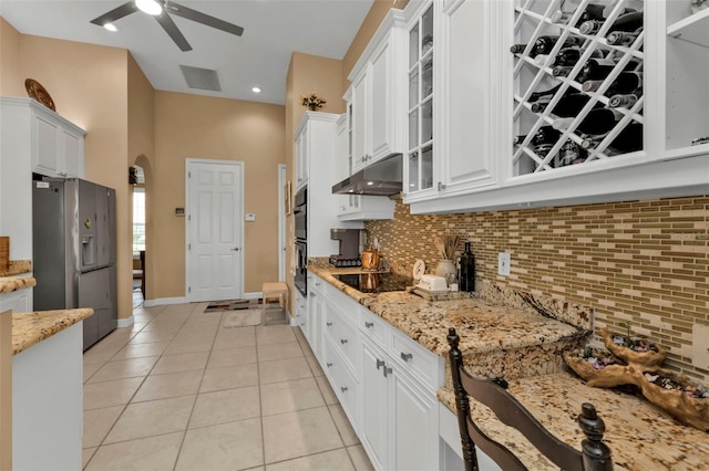 kitchen with ceiling fan, stainless steel refrigerator with ice dispenser, light stone counters, white cabinets, and light tile patterned flooring