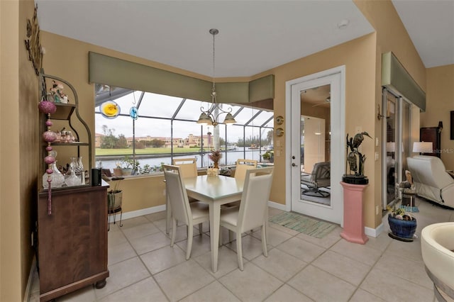 dining space with a water view and light tile patterned floors