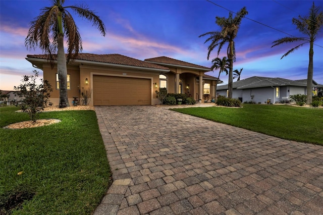 view of front of house with a garage and a lawn