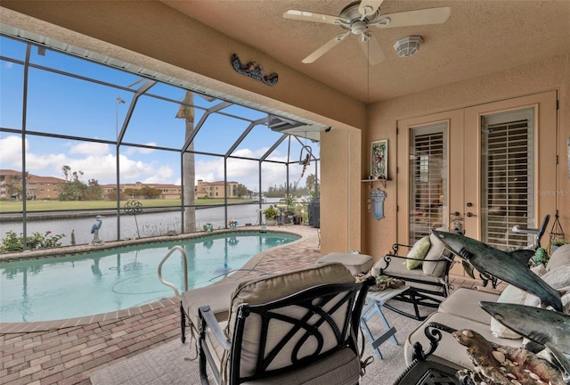 view of swimming pool with a water view, ceiling fan, a lanai, and a patio area