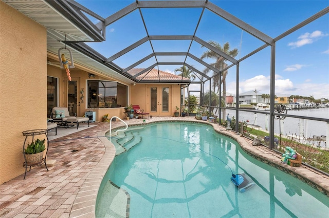 view of swimming pool featuring a lanai, a patio area, an outdoor bar, and a water view