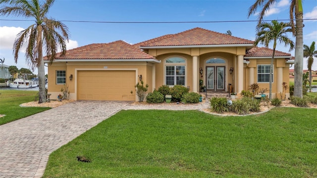 mediterranean / spanish house with a garage and a front lawn