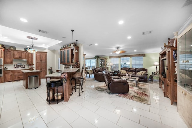 living room with ornamental molding, light tile patterned floors, and ceiling fan