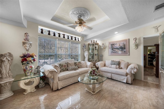 living room with ornamental molding, a tray ceiling, and ceiling fan