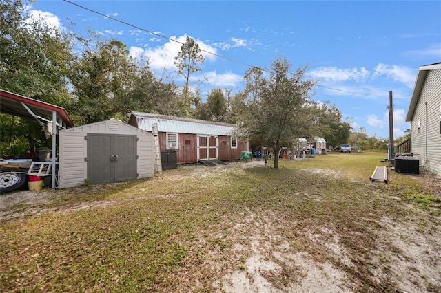 view of yard with central AC and a shed