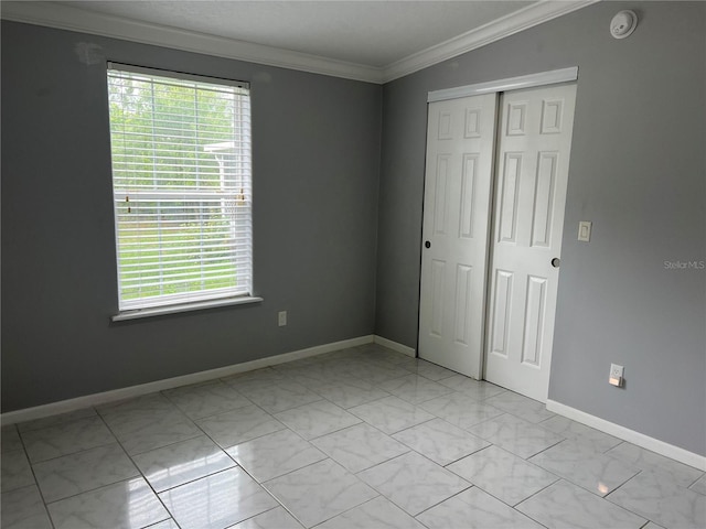 unfurnished bedroom featuring multiple windows, crown molding, and a closet