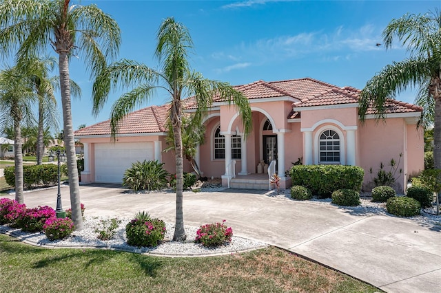 mediterranean / spanish home with a garage and a front lawn