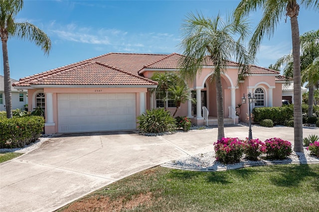 mediterranean / spanish-style home featuring a garage and a front lawn