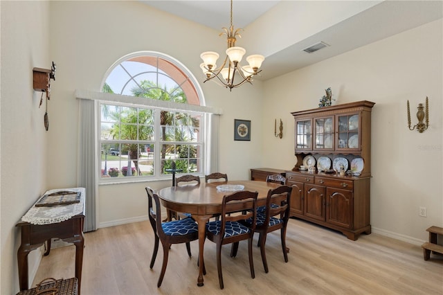 dining area with light hardwood / wood-style floors and a chandelier