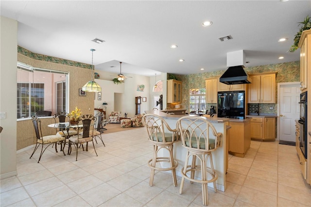 kitchen with hanging light fixtures, ceiling fan, plenty of natural light, and black fridge