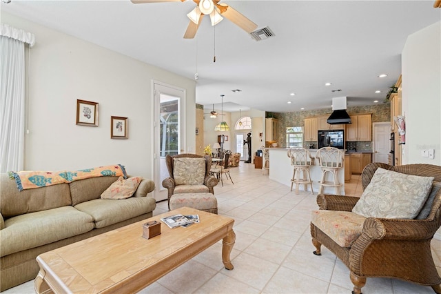 tiled living room featuring ceiling fan and plenty of natural light