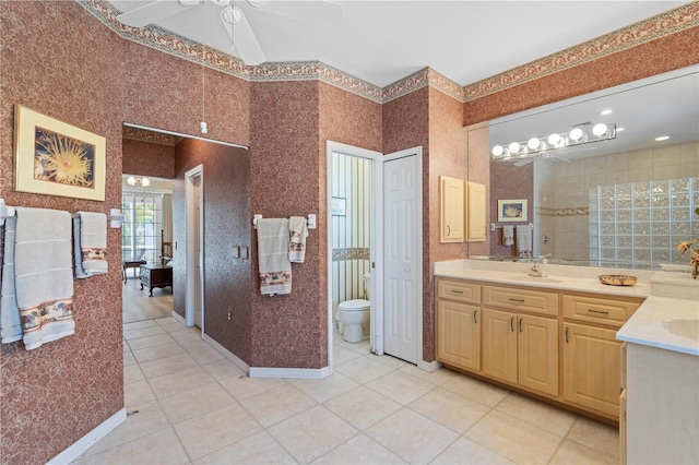 bathroom with toilet, vanity, ceiling fan, and tile patterned floors