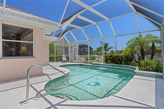 view of swimming pool with glass enclosure, pool water feature, and a patio area