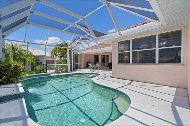 view of swimming pool featuring a patio area and a lanai