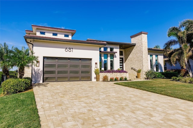 view of front of home with a front yard and a garage