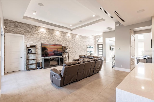 living room featuring a raised ceiling and light tile patterned floors