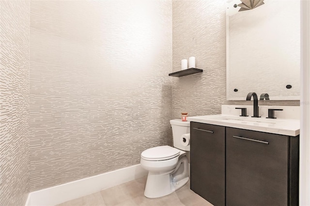 bathroom with tile patterned flooring, vanity, and toilet