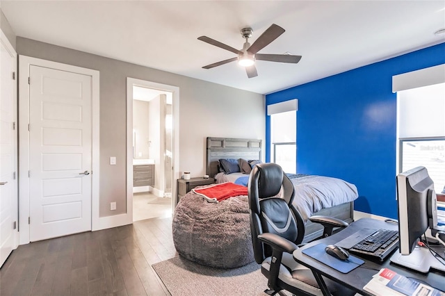 bedroom featuring multiple windows, ceiling fan, dark hardwood / wood-style flooring, and ensuite bath