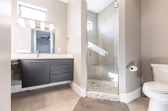 bathroom featuring ceiling fan, tile patterned floors, toilet, vanity, and a shower with shower door