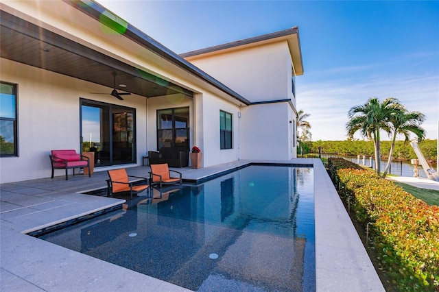 view of swimming pool with ceiling fan and a patio