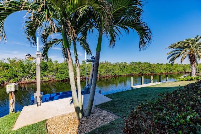 view of dock featuring a lawn and a water view