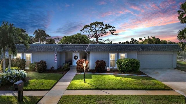 ranch-style house featuring a lawn and a garage