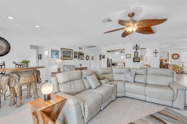 living room featuring ceiling fan, light tile patterned flooring, and ornamental molding