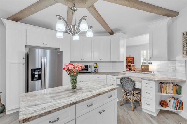 kitchen featuring decorative backsplash, stainless steel fridge, white cabinetry, and beam ceiling