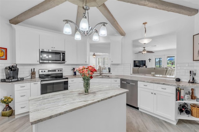 kitchen featuring pendant lighting, white cabinets, backsplash, and appliances with stainless steel finishes