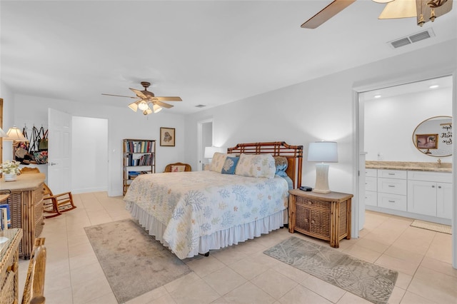 tiled bedroom featuring ceiling fan, sink, and ensuite bath