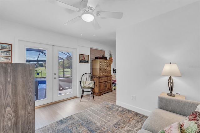 sitting room with hardwood / wood-style floors, ceiling fan, and french doors