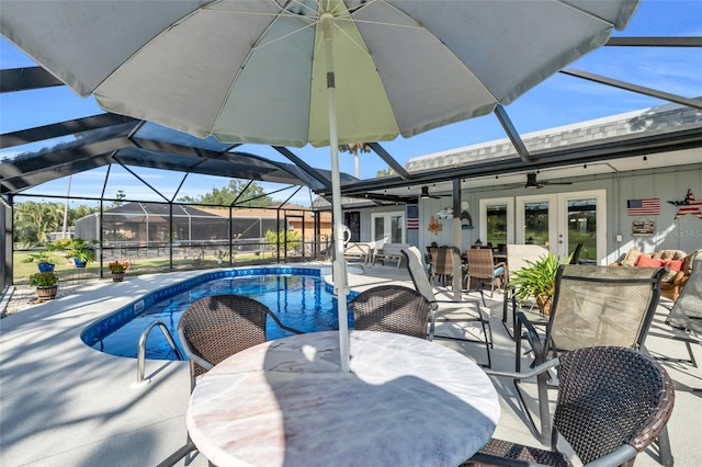 view of swimming pool with a lanai, ceiling fan, french doors, and a patio