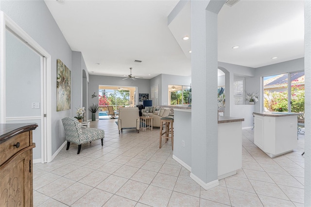 interior space with white cabinets, light tile patterned floors, and ceiling fan