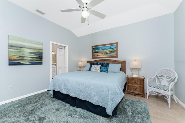 bedroom featuring connected bathroom, ceiling fan, light hardwood / wood-style flooring, and vaulted ceiling