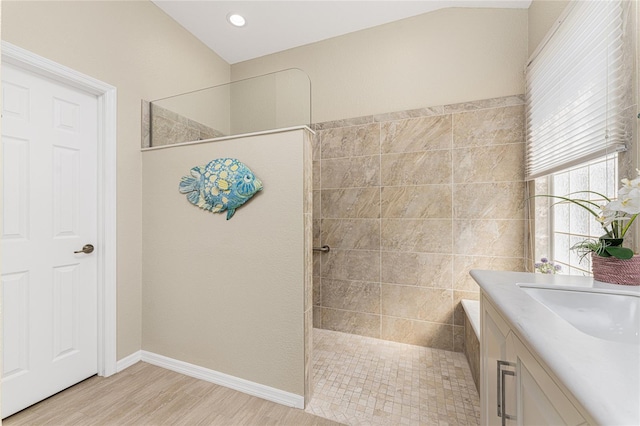 bathroom with hardwood / wood-style floors, vanity, and tiled shower